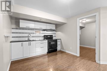 Orangeville apartment for rent - A kitchen with white cabinets and a black oven.