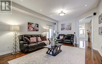 Brampton (Bram West) apartment for rent - A living room with a black leather couch and a coffee table.