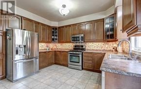 Brampton (Bram West) apartment for rent - A kitchen with wooden cabinets and a stainless steel refrigerator.