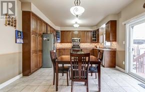 Brampton (Bram West) apartment for rent - A kitchen with brown cabinets and a table with chairs.