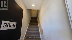 St. Catharines (E. Chester) townhouse for rent - A staircase with a black wall on the left and a white wall on the right.