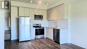 St. Catharines (E. Chester) townhouse for rent - A kitchen with white appliances and cabinets.
