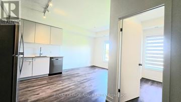 St. Catharines (E. Chester) townhouse for rent - A kitchen with white cabinets and a refrigerator.