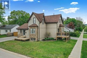 Collingwood multi-family for rent - A house with a brown roof and a porch is surrounded by a grassy lawn.