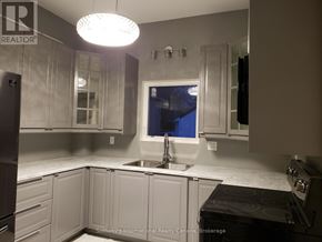 Collingwood duplex for rent - A kitchen with white cabinets and a black stove top.