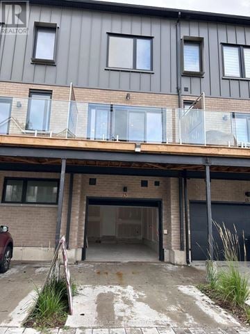 Barrie (Holly) townhouse for rent - A building with a grey facade and a balcony with glass railings.