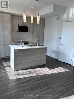 Barrie (Holly) townhouse for rent - A modern kitchen with a wooden island and a flat screen TV mounted above it.