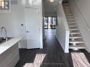Barrie (Holly) townhouse for rent - A modern kitchen with a white sink and a staircase leading to the upper floor.