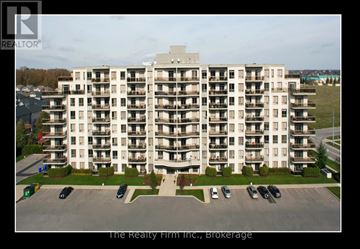 Woodstock (Woodstock - South) condo for rent - A large apartment complex with a parking lot in front.