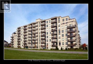 Woodstock (Woodstock - South) condo for rent - A large apartment building with a blue car parked in front.