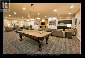 Woodstock (Woodstock - South) condo for rent - A billiard table is in the middle of a room with a television and a bookshelf in the background.