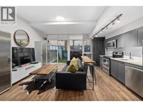 Vancouver apartment for rent - A modern kitchen with a wooden floor and stainless steel appliances.