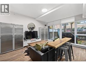 Vancouver apartment for rent - A modern living room with a wooden table and a television.