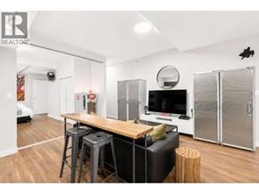 Vancouver apartment for rent - A modern living room with a wooden table and black couch.