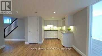 Southgate apartment for rent - A well-lit kitchen with white cabinets and a wooden floor.