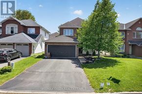 Ottawa apartment for rent - A house with a garage and a tree in front of it.