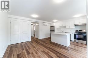 Kitchener apartment for rent - A kitchen with white cabinets and a wooden floor.