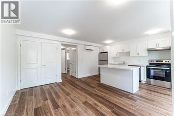 Kitchener apartment for rent - A kitchen with white cabinets and a wooden floor.