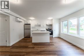 Kitchener apartment for rent - A kitchen with white cabinets and a wooden floor.