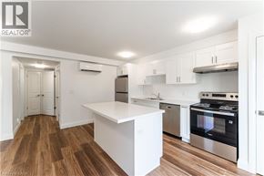 Kitchener apartment for rent - A kitchen with white cabinets and a wooden floor.