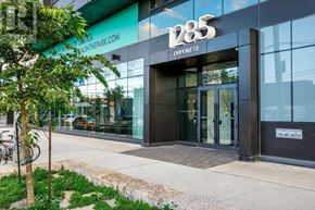 Toronto (Dovercourt-Wallace Emerson-Junction) condo for rent - A modern building with a glass facade and a tree in front.