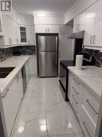 Toronto (Humber Summit) condo for rent - A kitchen with white cabinets and a marble floor.
