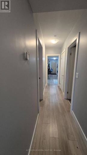 Toronto (Yorkdale-Glen Park) condo for rent - A long hallway with wood floors and white walls.