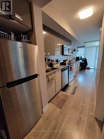 Waterloo condo for rent - A kitchen with a stainless steel refrigerator and wooden floors.