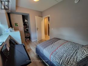 Waterloo condo for rent - A bedroom with a bed, a desk, and a closet.