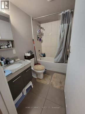 Waterloo condo for rent - A bathroom with a toilet, sink, and shower area.