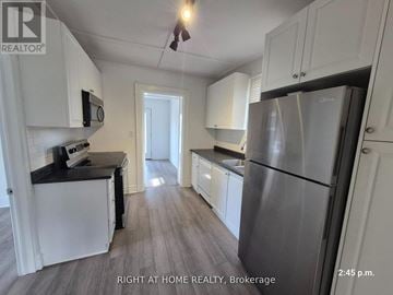 Oshawa (Central) apartment for rent - A kitchen with white cabinets and a stainless steel refrigerator.