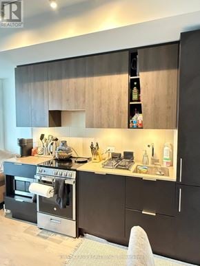 Mississauga (City Centre) condo for rent - A modern kitchen with black cabinets and a stove top oven.