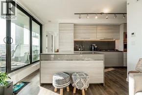 Burnaby apartment for rent - A modern kitchen with a large island and a chair with a patterned cushion.