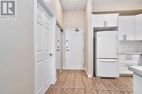 Hamilton (Waterdown) condo for rent - A kitchen with a refrigerator, cabinets, and a tile floor.