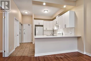 Hamilton (Waterdown) condo for rent - A kitchen area with white cabinets and a countertop.