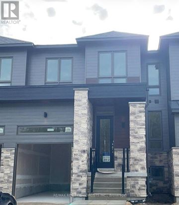 Wasaga Beach townhouse for rent - A modern house with a black car parked in front.