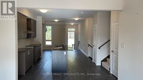 Wasaga Beach townhouse for rent - A spacious kitchen with dark wood floors and white walls.