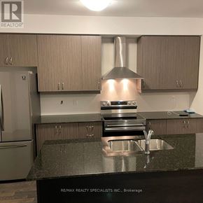 Wasaga Beach townhouse for rent - A kitchen with a sink and a refrigerator.