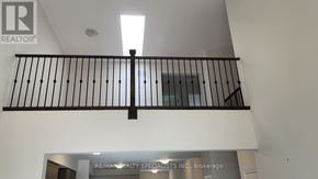 Wasaga Beach townhouse for rent - A balcony with a metal railing and a sign that says RE/MAX Realty Specialists Inc. Brokerage.