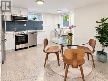 Toronto (High Park North) apartment for rent - A modern kitchen with a glass table and chairs.