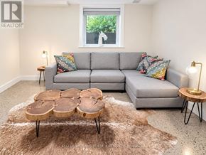 Toronto (High Park North) apartment for rent - A living room with a grey couch, a brown rug, and a wooden coffee table.
