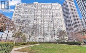 Mississauga (City Centre) condo for rent - A tall residential building with a lawn in front.