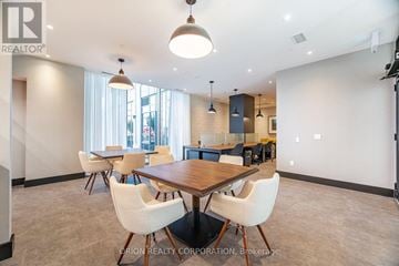 Milton (Om Old Milton) condo for rent - A dining room with a wooden table and white chairs.