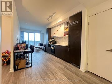 Toronto (Waterfront Communities) condo for rent - A kitchen with a dining table and chairs is shown in the image.