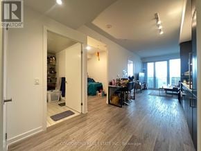 Toronto (Waterfront Communities) condo for rent - A spacious living room with a kitchen area in the background.