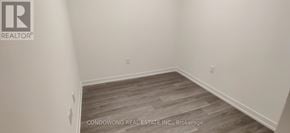 Toronto (Waterfront Communities) condo for rent - A room with a wooden floor and white walls.