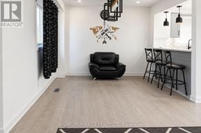 Toronto (Malvern) apartment for rent - A black leather chair sits in a room with a wooden floor and a wall hanging.