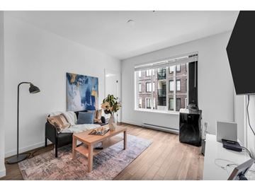 Surrey apartment for rent - A living room with a couch, a coffee table, a lamp, and a painting on the wall.