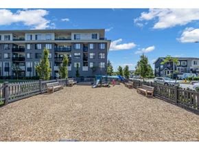 Surrey apartment for rent - A playground area with a slide and swings in front of apartment buildings.