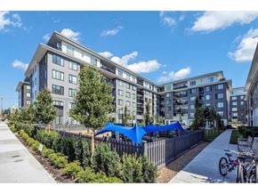 Surrey apartment for rent - A modern apartment complex with a bicycle parked on the sidewalk.